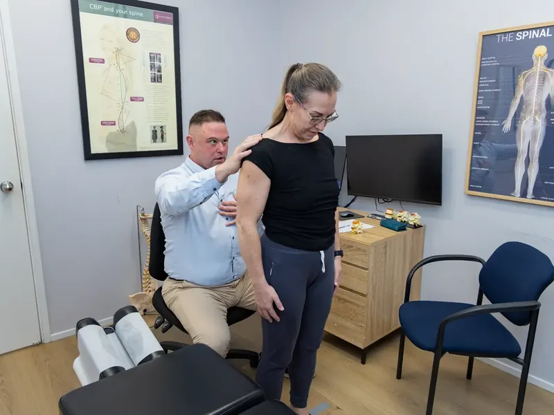 Dr Michael Charlton (Chiropractor) checking movement with an adult at the Redbank clinic